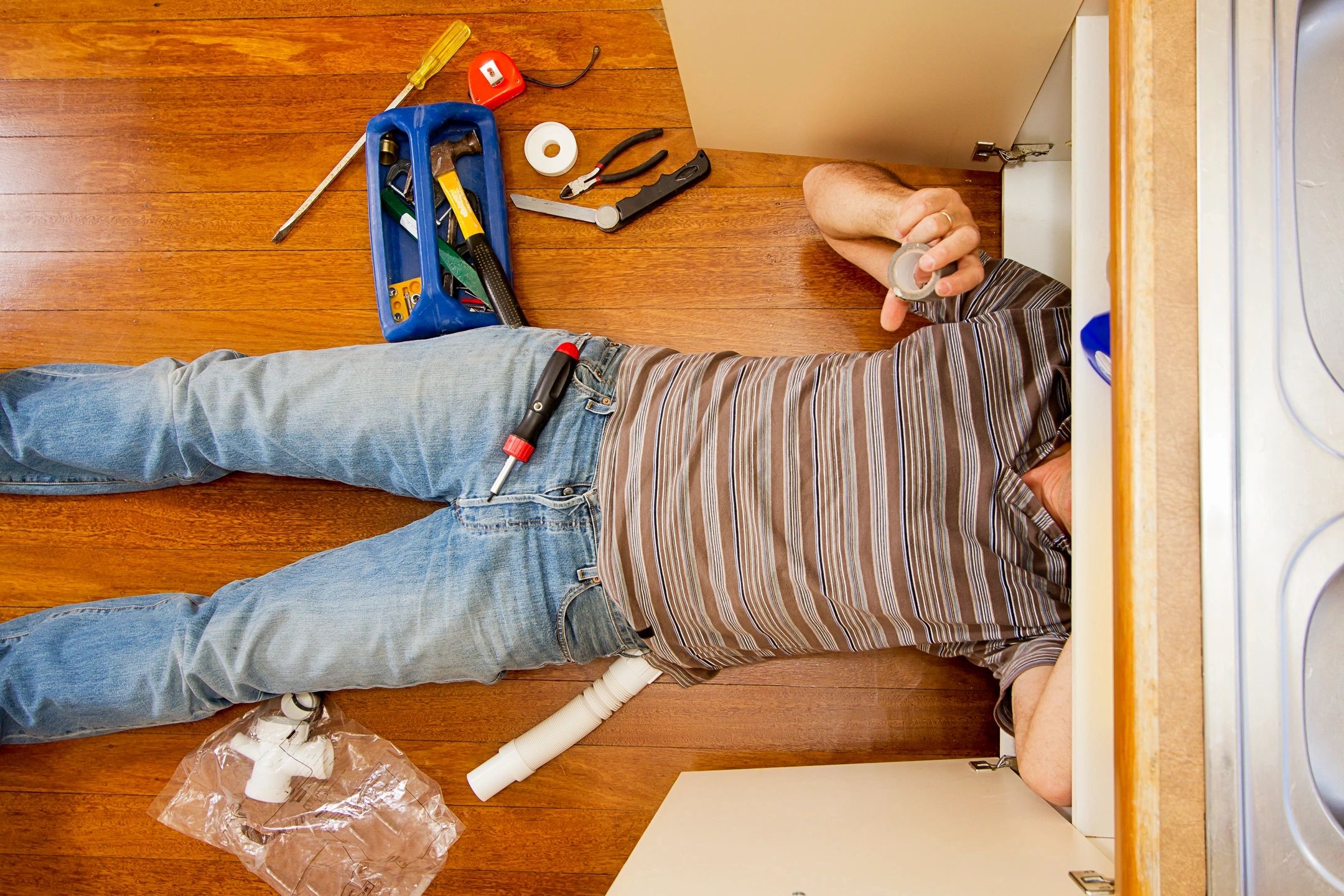 A man laying on the floor in front of boxes.