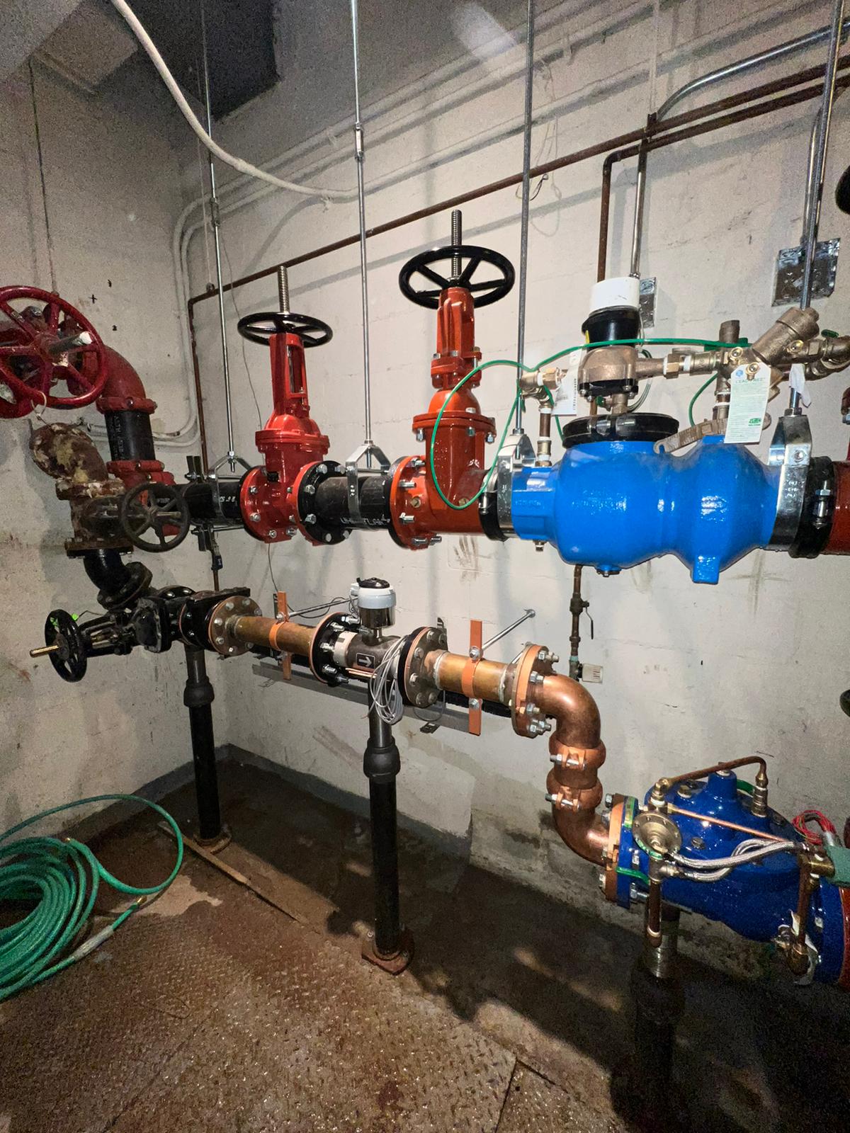 A room filled with pipes and valves next to a wall.